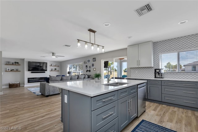 kitchen with ceiling fan, gray cabinets, dishwasher, and a center island with sink