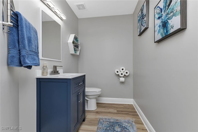 bathroom with hardwood / wood-style flooring, vanity, and toilet