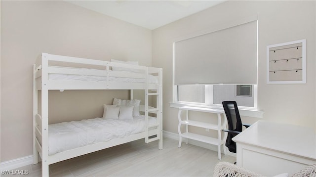 bedroom featuring baseboards and wood finished floors