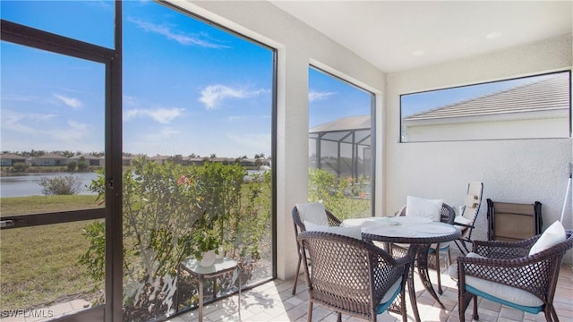 sunroom featuring a water view