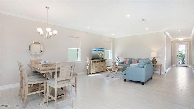 dining space featuring light wood-style floors, a notable chandelier, ornamental molding, and baseboards