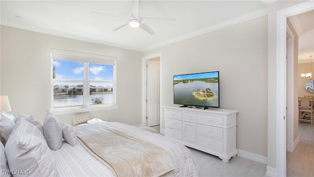 bedroom featuring baseboards, ornamental molding, light wood-style flooring, and ceiling fan with notable chandelier