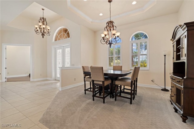 tiled dining room with plenty of natural light, a chandelier, and a raised ceiling