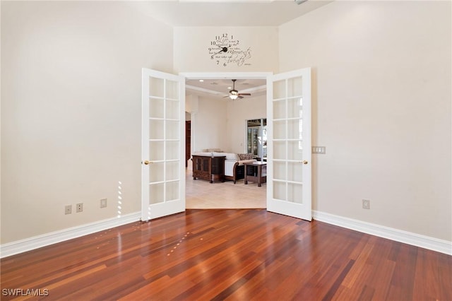 empty room with wood-type flooring, ceiling fan, and french doors