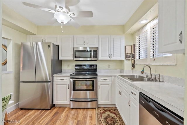 kitchen featuring white cabinetry, appliances with stainless steel finishes, sink, and light hardwood / wood-style flooring