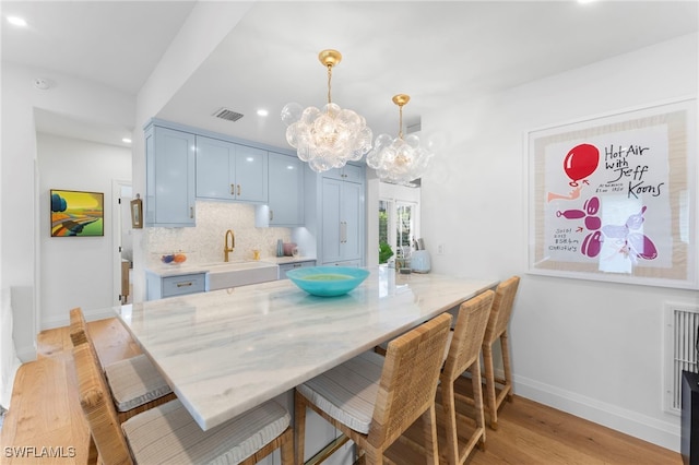 dining space with sink and light wood-type flooring