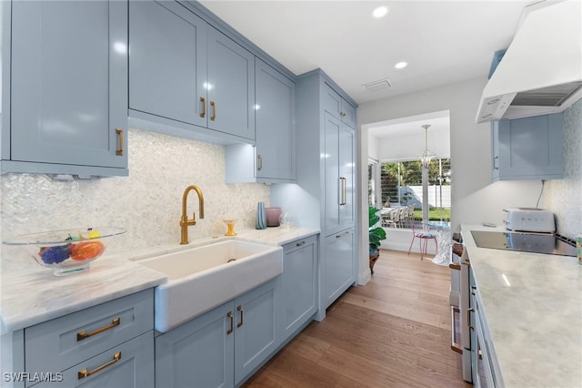 kitchen featuring sink, stainless steel stove, backsplash, dark hardwood / wood-style flooring, and custom exhaust hood