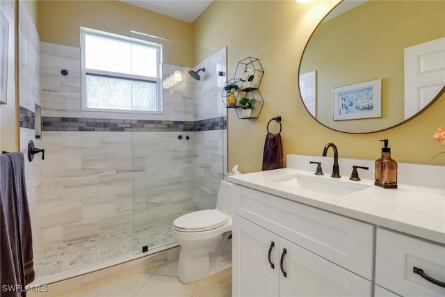 bathroom with vanity, a tile shower, tile patterned floors, and toilet