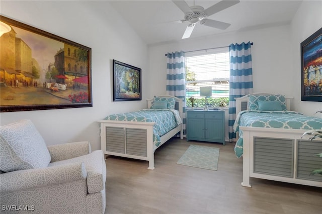 bedroom featuring ceiling fan, wood-type flooring, and vaulted ceiling