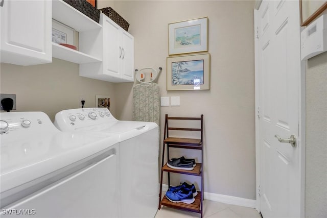 laundry room featuring separate washer and dryer, cabinets, and light tile patterned flooring