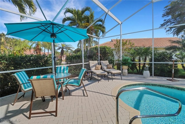 view of pool with glass enclosure and a patio area