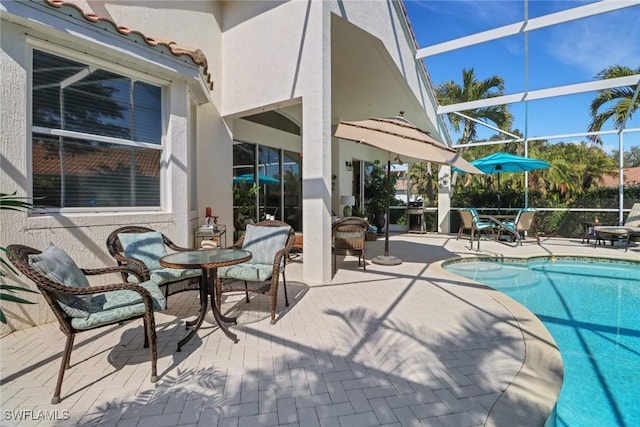 view of swimming pool featuring a patio area and glass enclosure