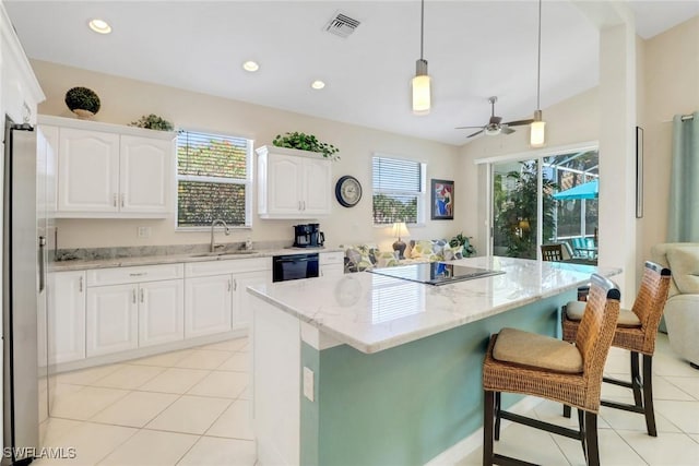 kitchen with white cabinetry, hanging light fixtures, sink, and a kitchen island