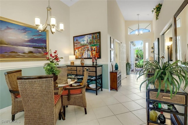 dining room with an inviting chandelier, light tile patterned floors, and a high ceiling