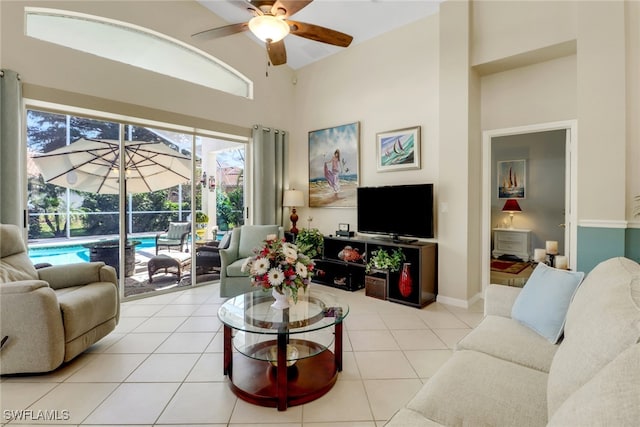 tiled living room with ceiling fan and a towering ceiling