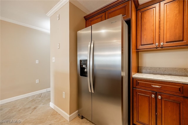 3458 Hancock Bridge Pkwy Unit 114, North Fort Myers, FL 33903 - kitchen featuring stainless steel refrigerator with ice dispenser, ornamental molding, brown cabinets, baseboards, and light stone counters