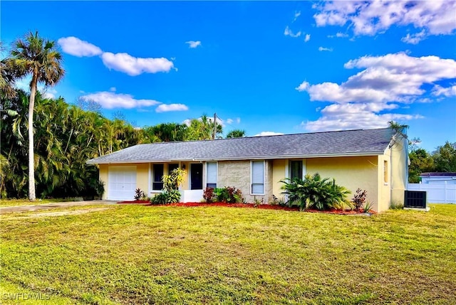 ranch-style house featuring a garage, central AC unit, and a front lawn