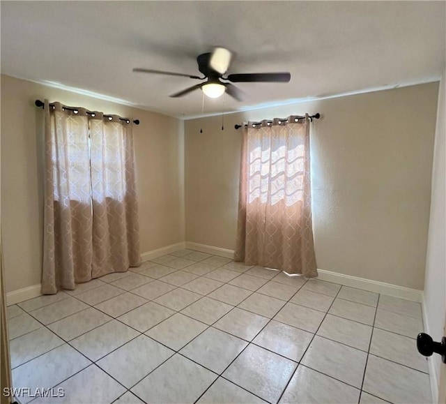 spare room with ceiling fan and light tile patterned floors