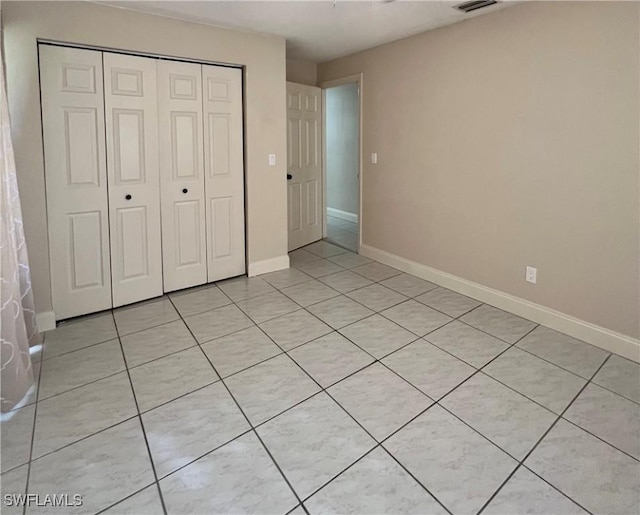 unfurnished bedroom featuring a closet and light tile patterned flooring