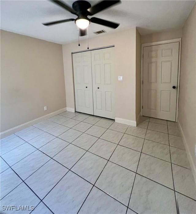 unfurnished bedroom featuring light tile patterned floors, a closet, and ceiling fan