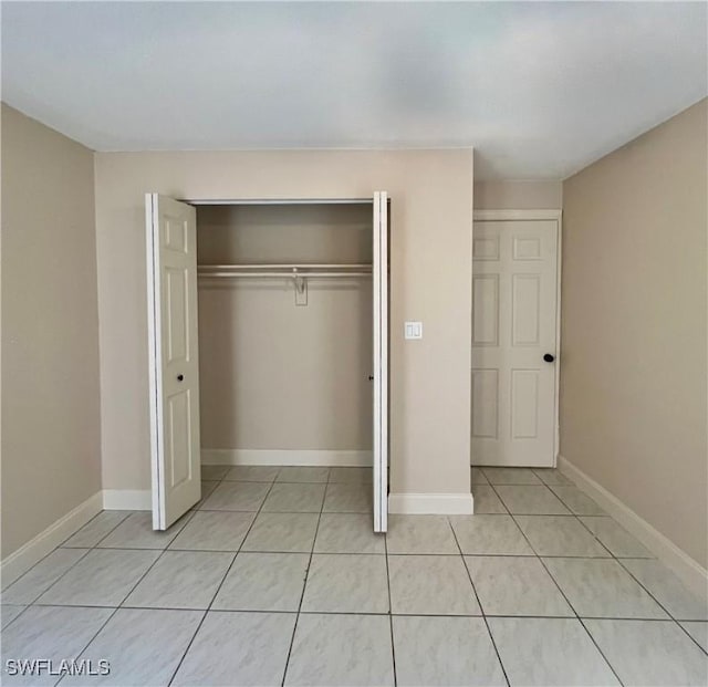 unfurnished bedroom with light tile patterned floors and a closet