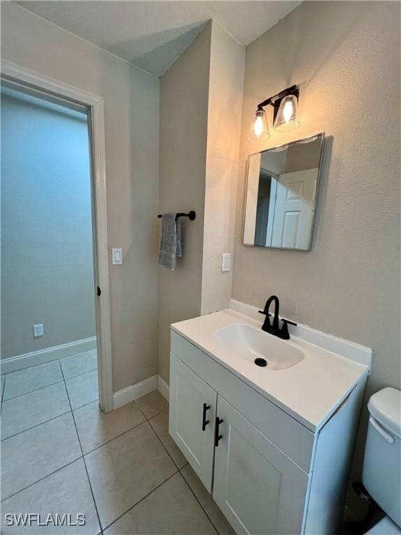 bathroom with vanity, toilet, and tile patterned flooring