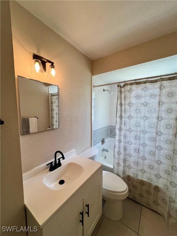 full bathroom featuring vanity, shower / tub combo, tile patterned floors, and toilet