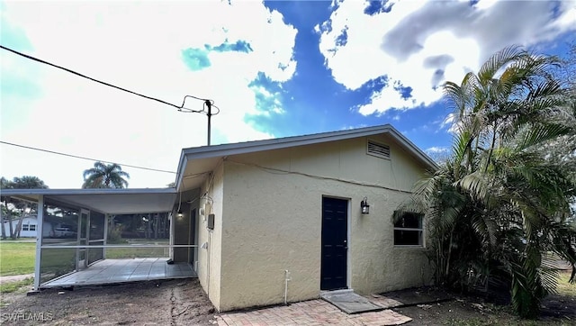 back of house featuring a sunroom and a patio