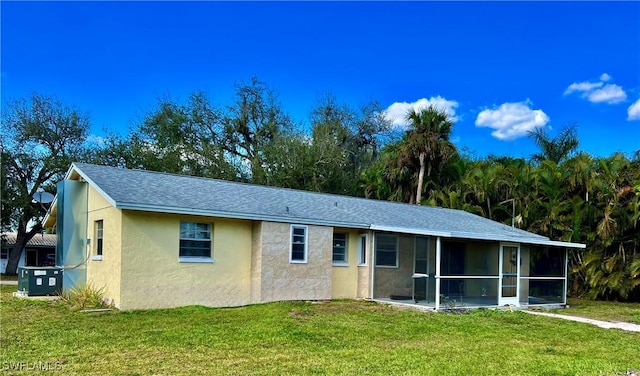 ranch-style house with cooling unit, a front lawn, and a sunroom