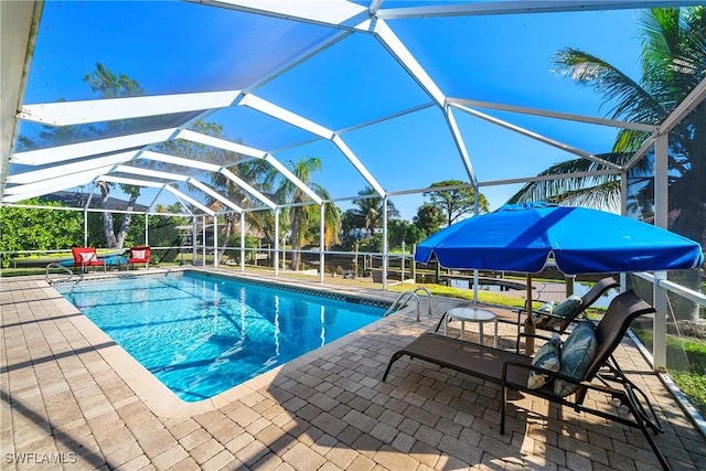 view of swimming pool featuring a lanai and a patio area