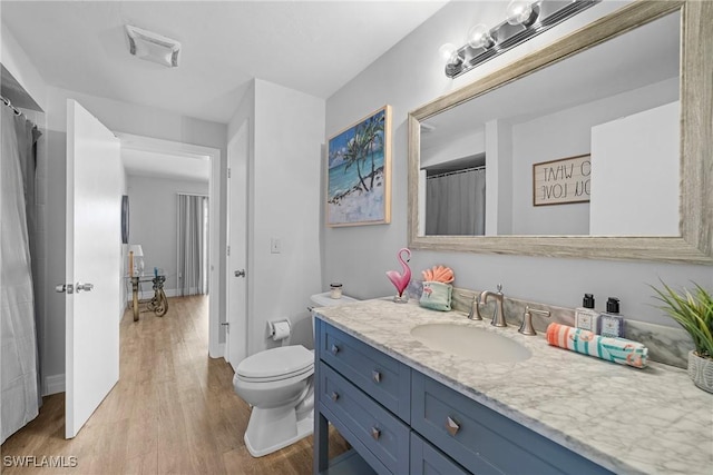 bathroom with vanity, wood-type flooring, and toilet