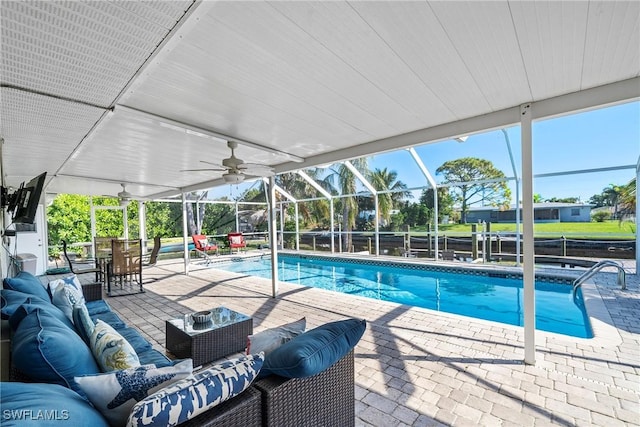 view of pool featuring ceiling fan, outdoor lounge area, a patio area, and a lanai