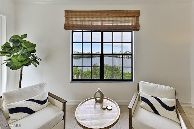 sitting room with a water view and tile patterned flooring