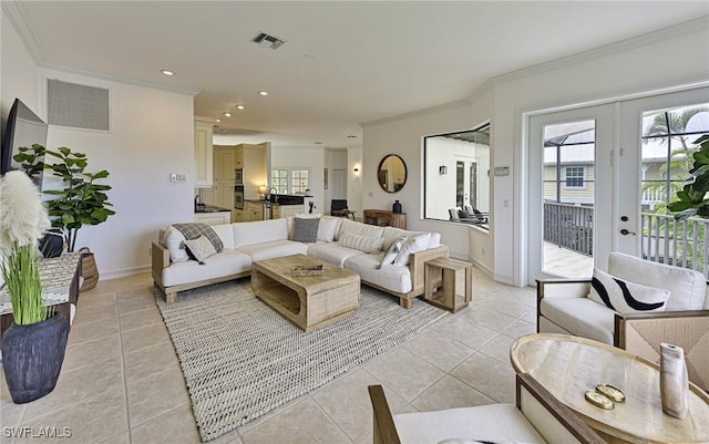 living room with light tile patterned floors, ornamental molding, and french doors