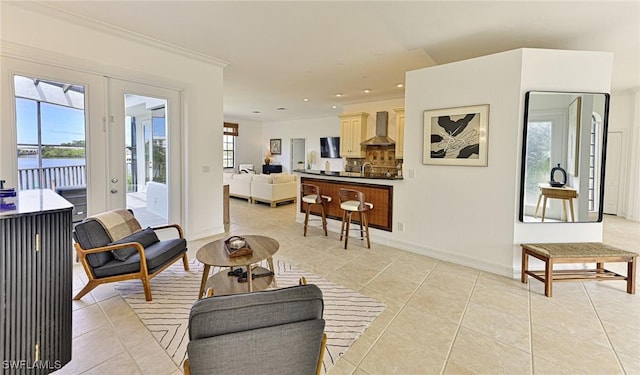 living room with french doors, ornamental molding, and light tile patterned floors