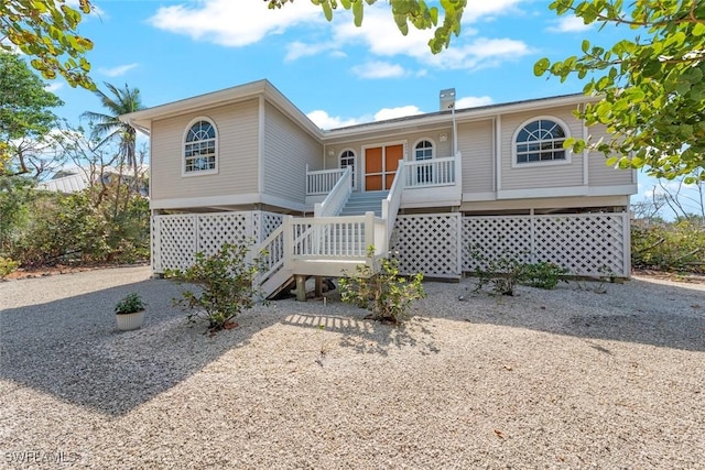 view of front of property featuring covered porch and stairway