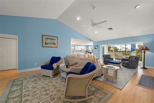 living room with baseboards, visible vents, and wood finished floors