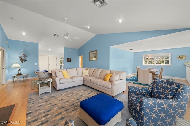 living area with visible vents, a ceiling fan, vaulted ceiling, wood finished floors, and baseboards