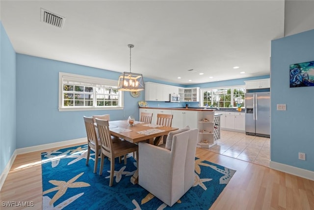 dining room featuring light wood-style flooring, recessed lighting, visible vents, and baseboards