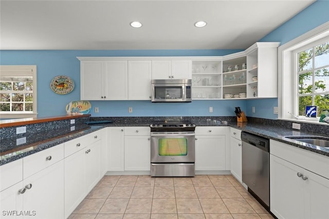 kitchen with stainless steel appliances, white cabinetry, and open shelves