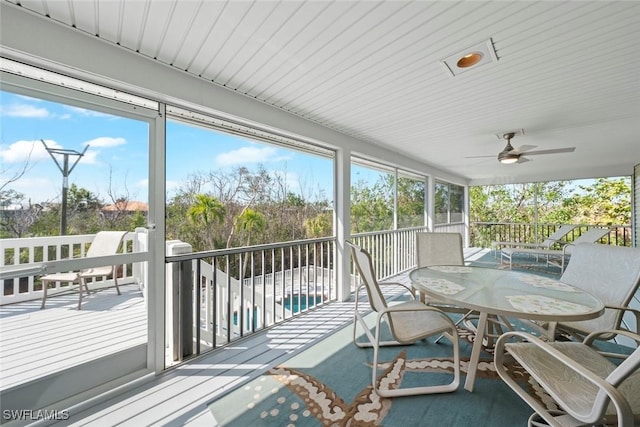 sunroom / solarium featuring ceiling fan