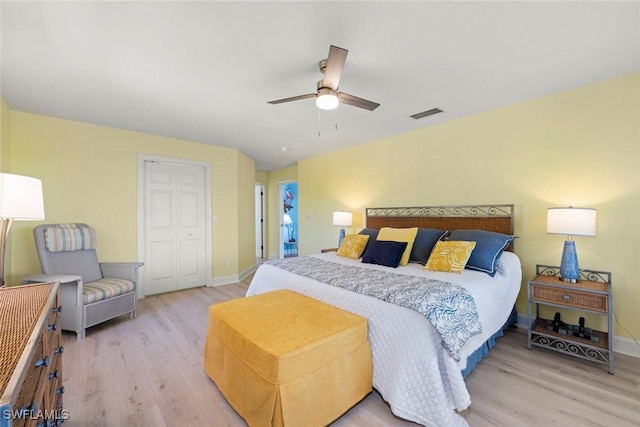 bedroom featuring visible vents, baseboards, a ceiling fan, a closet, and light wood finished floors