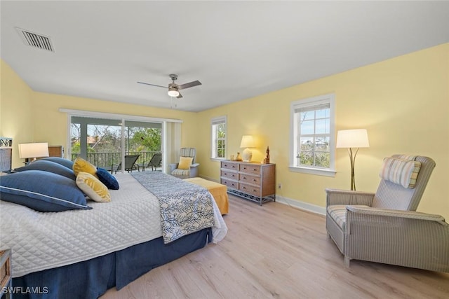 bedroom with light wood finished floors, access to outside, multiple windows, and visible vents