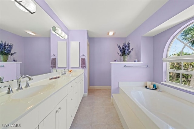 full bathroom featuring a garden tub, double vanity, a sink, and tile patterned floors