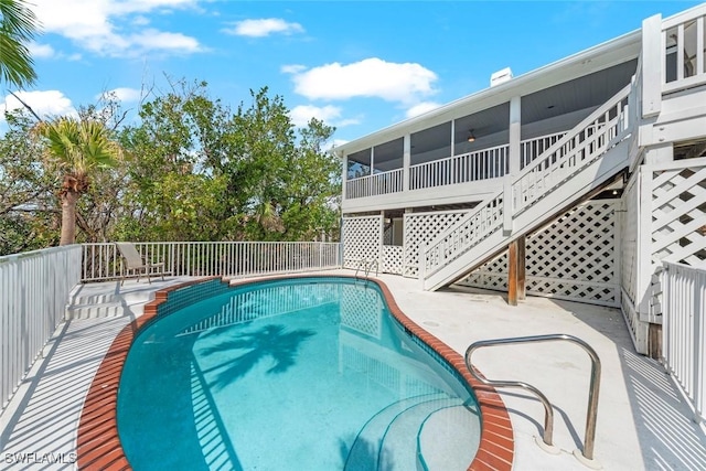 view of pool with a fenced in pool, a sunroom, fence, and stairway