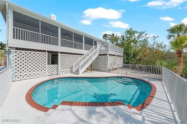 view of pool featuring a fenced in pool, a sunroom, and stairway