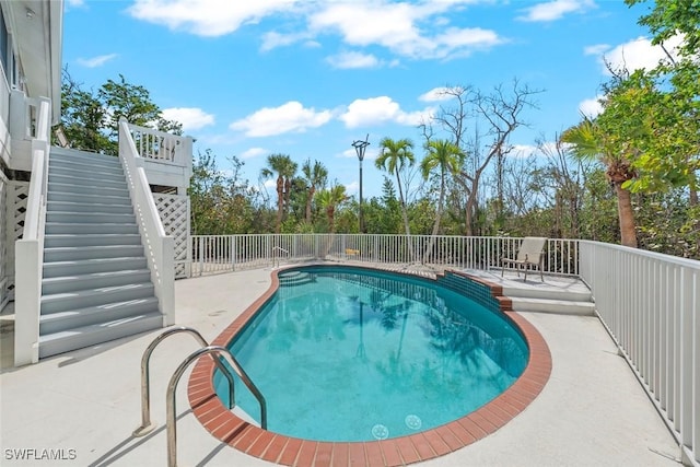 view of pool featuring stairway, a fenced in pool, and a patio