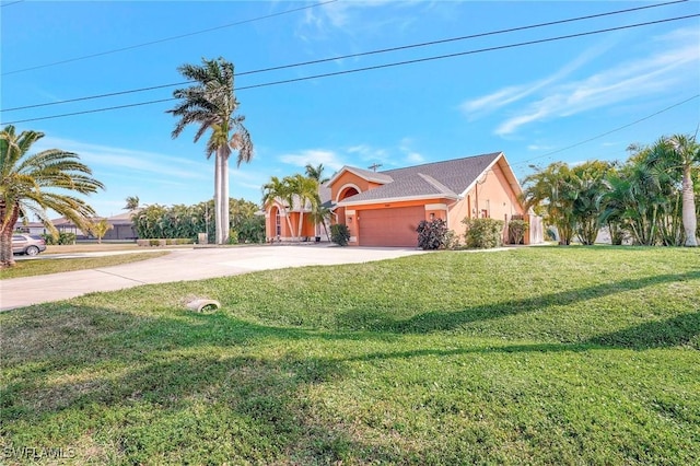 view of front of property featuring a garage, stucco siding, driveway, and a front yard