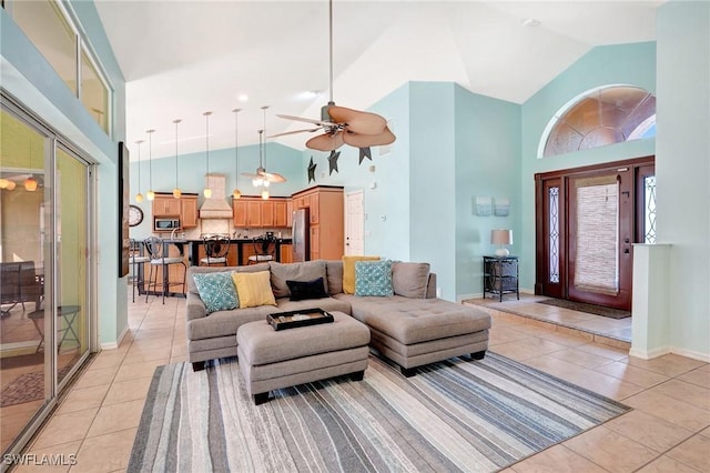 living area featuring light tile patterned floors, baseboards, and high vaulted ceiling