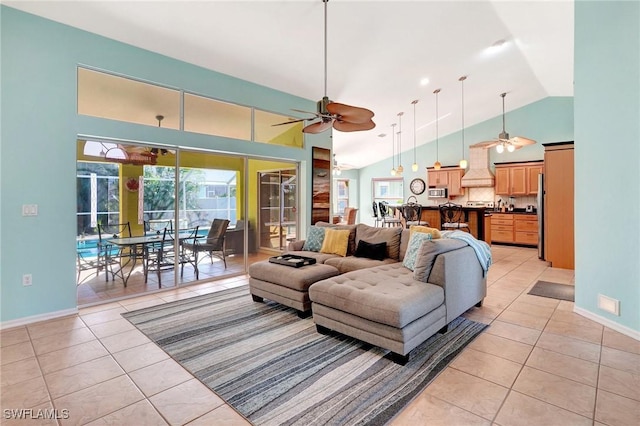 living area featuring light tile patterned floors, high vaulted ceiling, and a ceiling fan